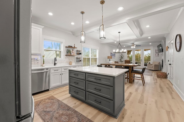 kitchen featuring a center island, light hardwood / wood-style flooring, hanging light fixtures, appliances with stainless steel finishes, and white cabinets