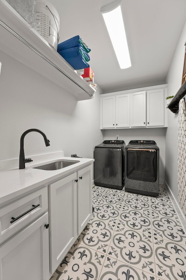 laundry room featuring cabinets, washer and dryer, sink, and light tile patterned floors