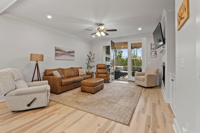 living room featuring light hardwood / wood-style flooring, ornamental molding, and ceiling fan