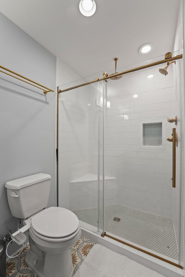 bathroom featuring tile patterned flooring, toilet, and walk in shower