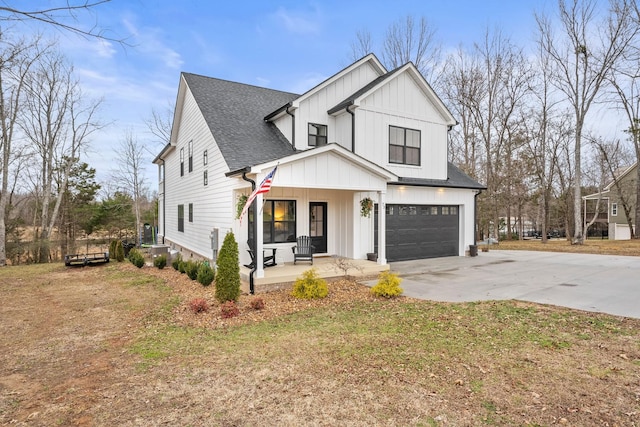 modern farmhouse featuring a porch, a garage, and a front lawn