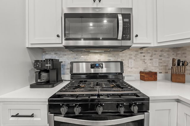 kitchen with tasteful backsplash, stainless steel appliances, and white cabinets