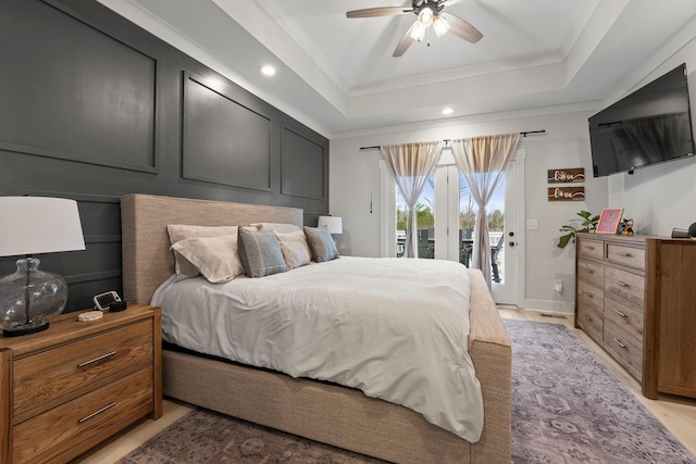 bedroom with crown molding, a tray ceiling, access to outside, and ceiling fan