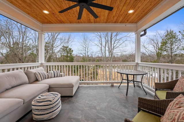 sunroom with ceiling fan and wooden ceiling