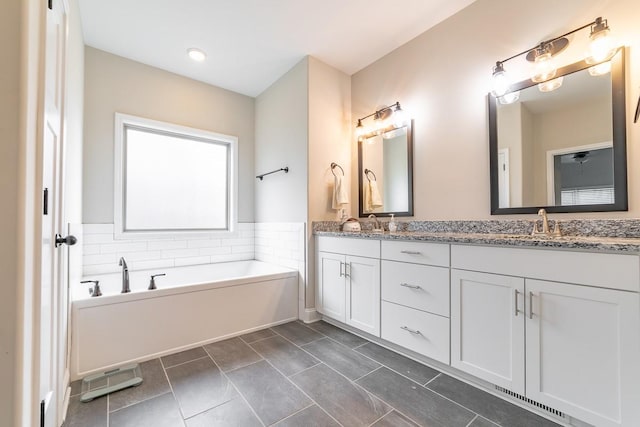 bathroom with vanity, a washtub, and tile patterned flooring