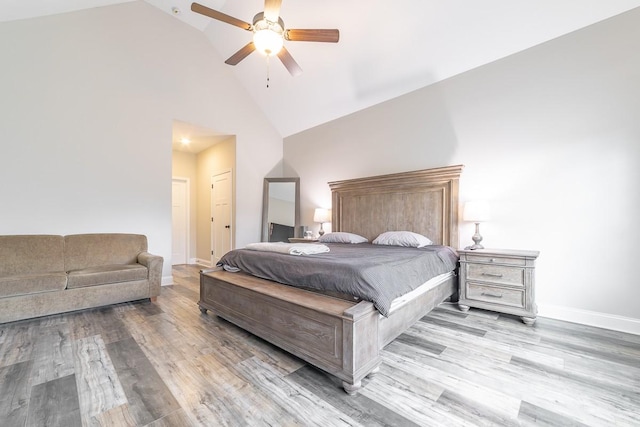 bedroom with ceiling fan, high vaulted ceiling, and light hardwood / wood-style floors