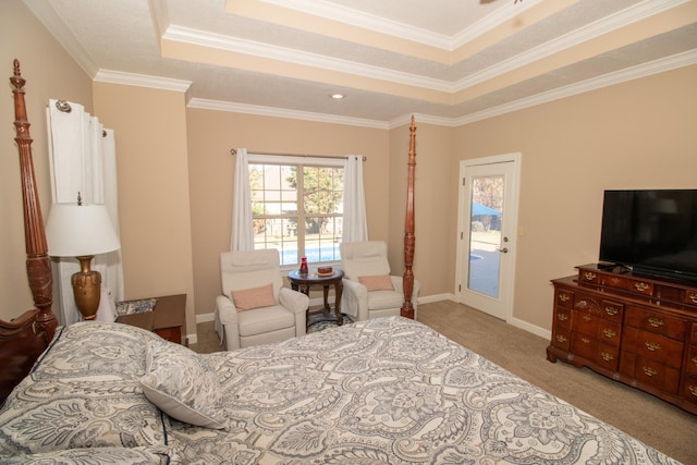 carpeted bedroom with access to exterior, a tray ceiling, and ornamental molding