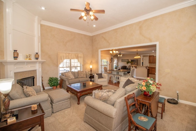 carpeted living room featuring crown molding, a fireplace, and ceiling fan with notable chandelier