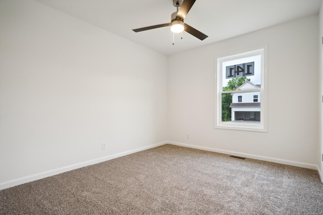 empty room featuring a ceiling fan, visible vents, baseboards, and carpet flooring