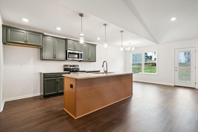 kitchen featuring dark wood-style floors, appliances with stainless steel finishes, a sink, and light stone counters