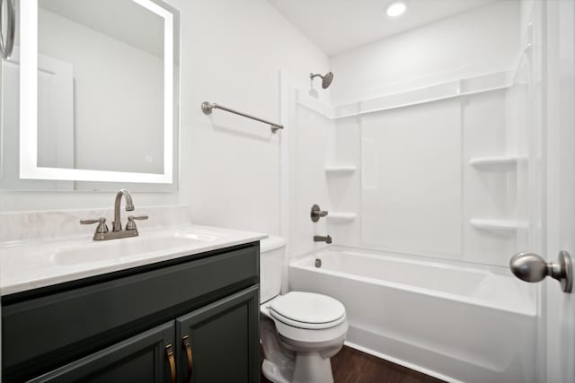 full bath featuring washtub / shower combination, wood finished floors, vanity, and toilet