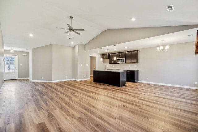 unfurnished living room with lofted ceiling, sink, ceiling fan with notable chandelier, and light hardwood / wood-style floors