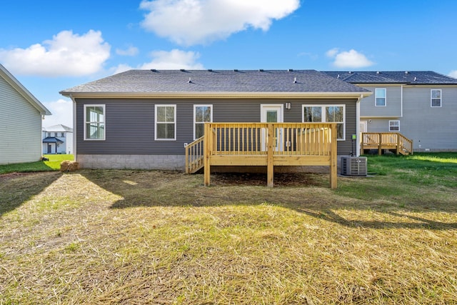 rear view of property featuring a yard, cooling unit, and a deck