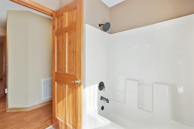 bathroom featuring hardwood / wood-style floors and tub / shower combination