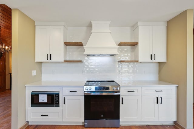 kitchen featuring white cabinetry, black microwave, and stainless steel range with electric stovetop