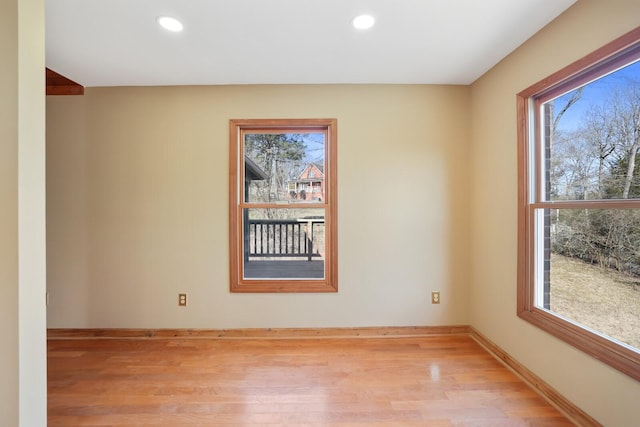 empty room with a healthy amount of sunlight and light hardwood / wood-style floors