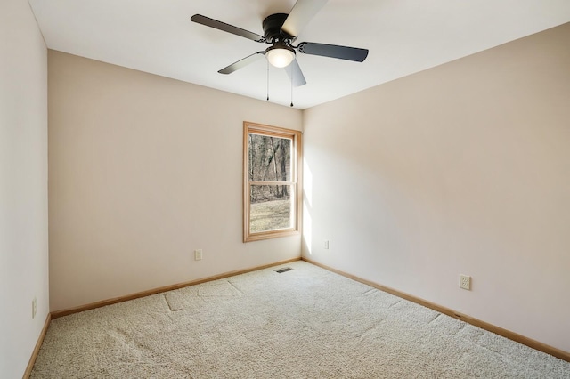 carpeted spare room featuring ceiling fan