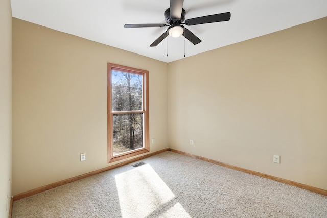 carpeted spare room featuring ceiling fan