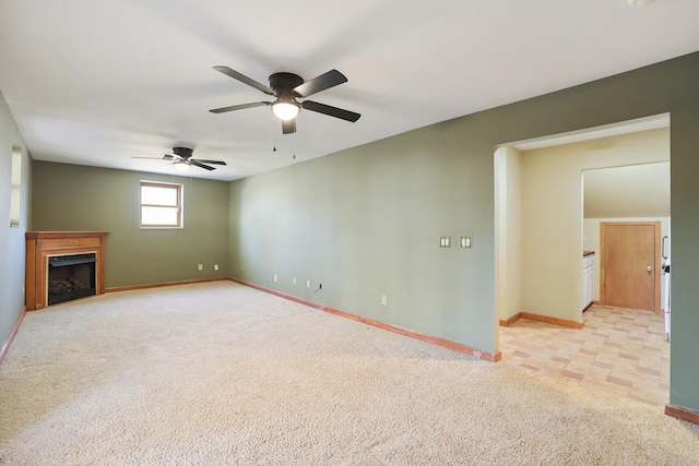 unfurnished living room with light carpet and ceiling fan