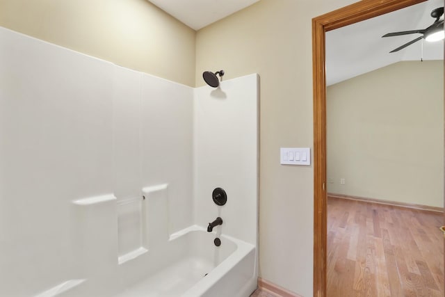 bathroom featuring lofted ceiling, hardwood / wood-style flooring, shower / tub combination, and ceiling fan