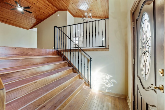 foyer entrance with wood ceiling, wood-type flooring, high vaulted ceiling, and ceiling fan with notable chandelier