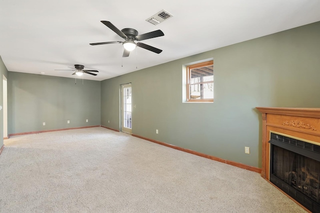 unfurnished living room with ceiling fan, a healthy amount of sunlight, and carpet