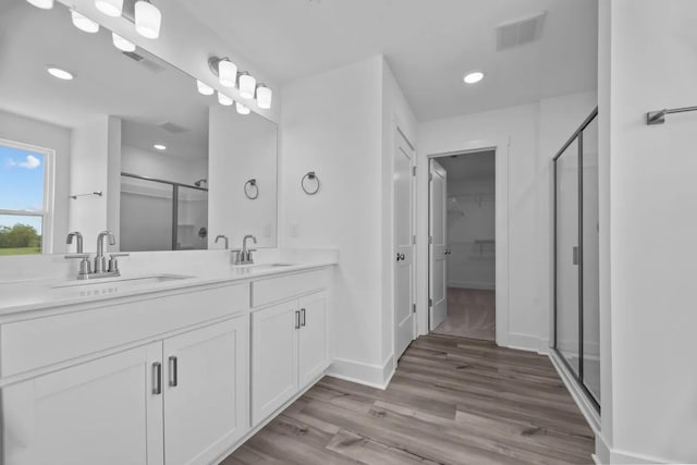 bathroom with vanity, hardwood / wood-style floors, and a shower with shower door