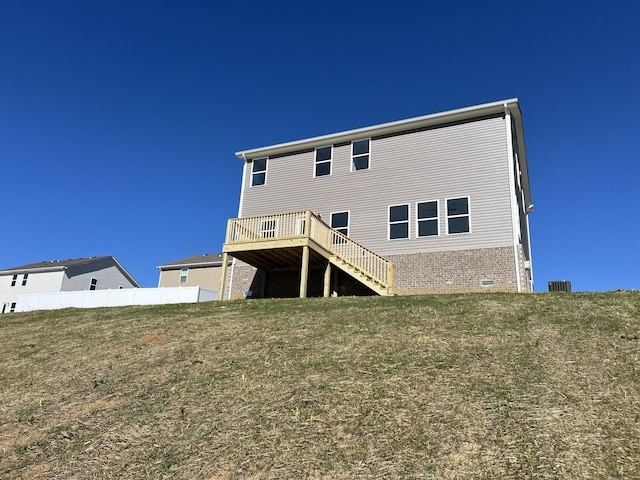 rear view of house with a deck and a lawn