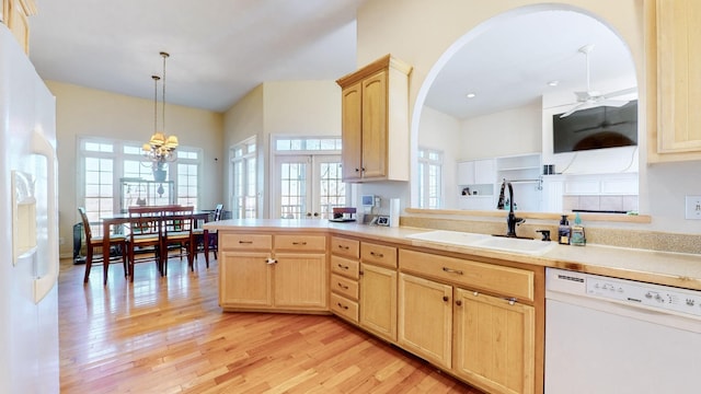 kitchen featuring light brown cabinetry, sink, light hardwood / wood-style flooring, pendant lighting, and white appliances