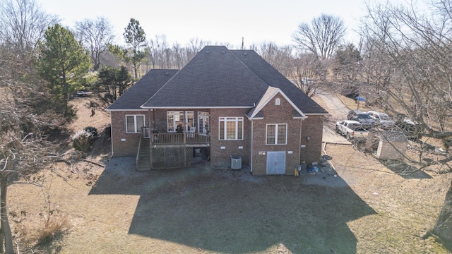 rear view of property featuring a yard, central AC, and a deck