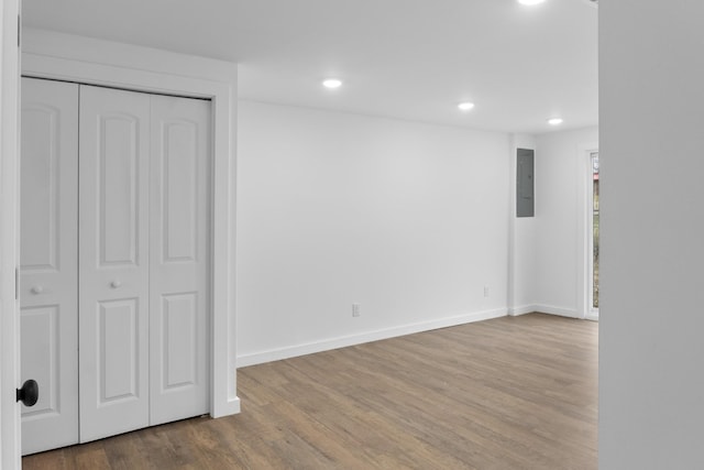 interior space featuring wood-type flooring, electric panel, and a closet