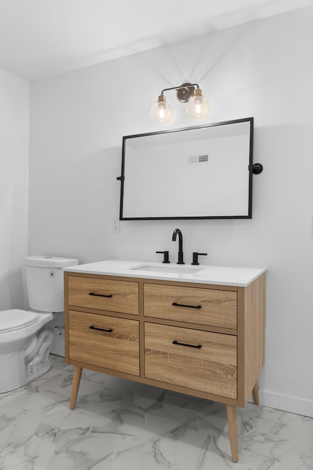 bathroom featuring vanity and toilet