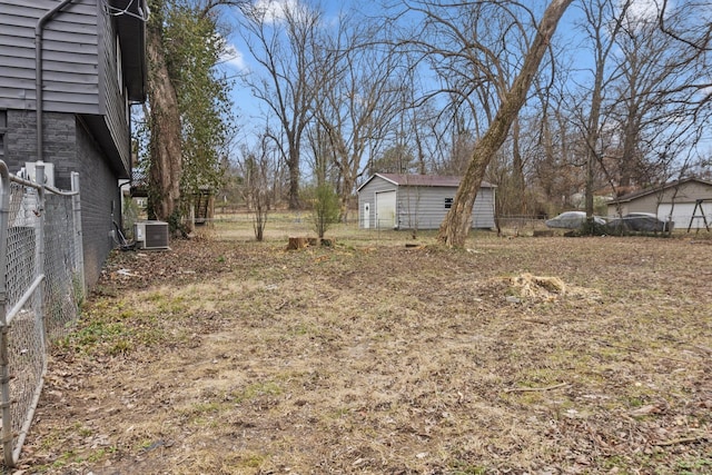 view of yard featuring a storage shed and central AC unit