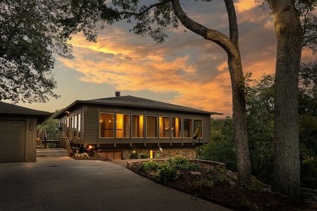 back house at dusk with a garage