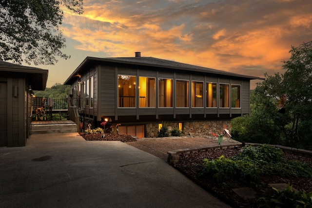 back house at dusk with a deck and a patio area