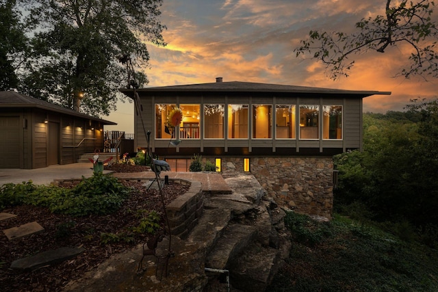 back house at dusk featuring a patio area