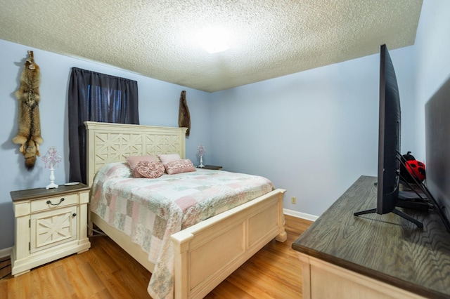 bedroom with light hardwood / wood-style flooring and a textured ceiling