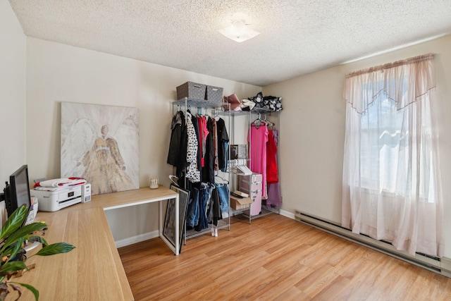 spacious closet featuring light hardwood / wood-style floors and baseboard heating