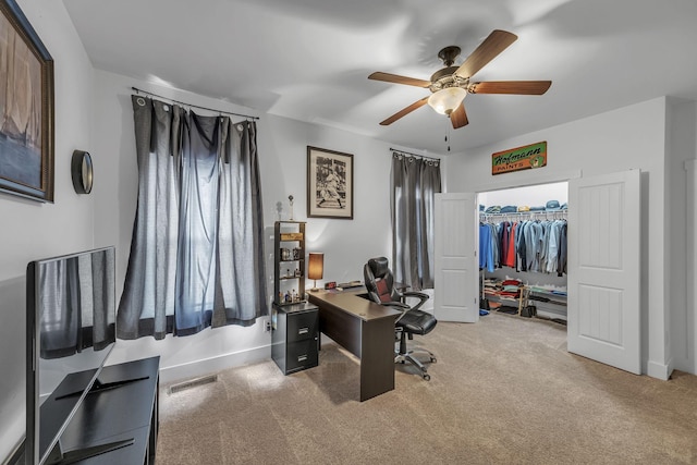 carpeted office space featuring ceiling fan