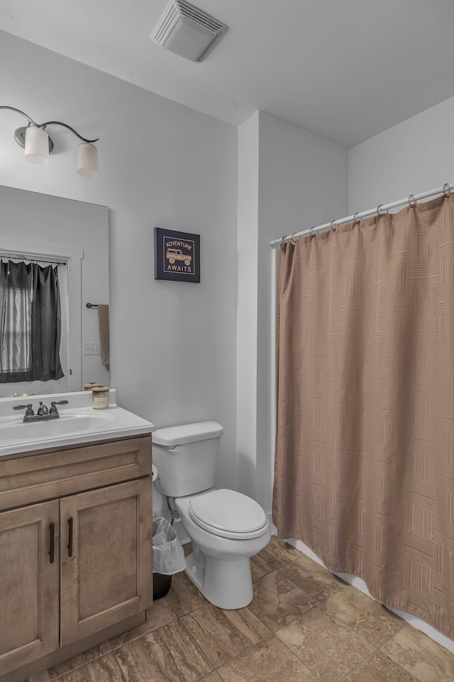 bathroom with vanity, walk in shower, and toilet