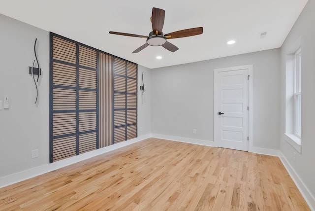 empty room with ceiling fan and light hardwood / wood-style floors