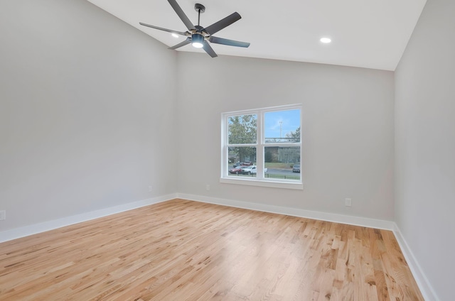 empty room featuring vaulted ceiling, light hardwood / wood-style floors, and ceiling fan