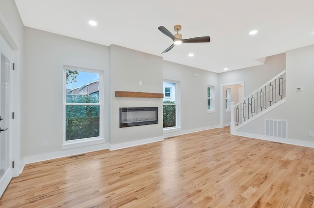 unfurnished living room featuring ceiling fan and light hardwood / wood-style floors