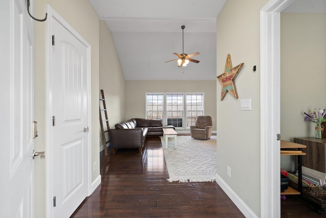 living room featuring ceiling fan, dark hardwood / wood-style flooring, and vaulted ceiling