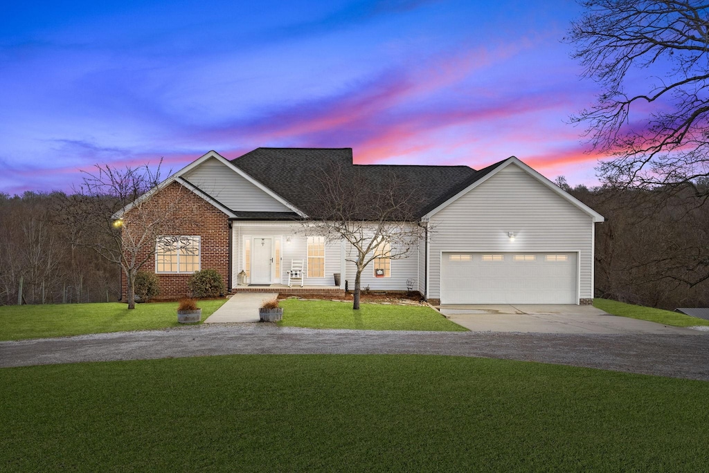 view of front of house featuring a garage and a lawn