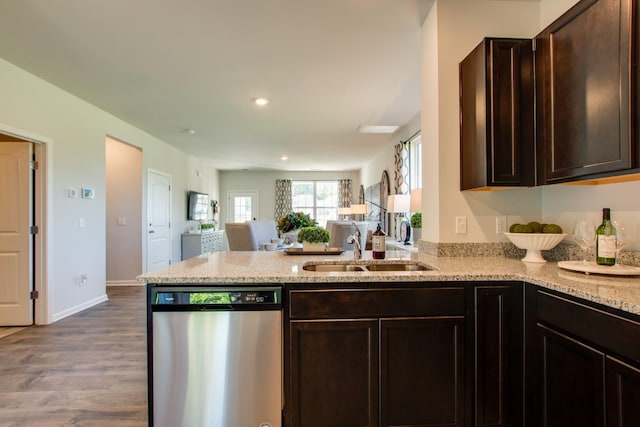 kitchen featuring dark brown cabinetry, sink, wood-type flooring, dishwasher, and kitchen peninsula