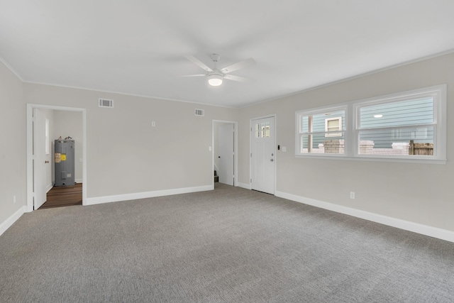 carpeted spare room with crown molding, ceiling fan, and water heater