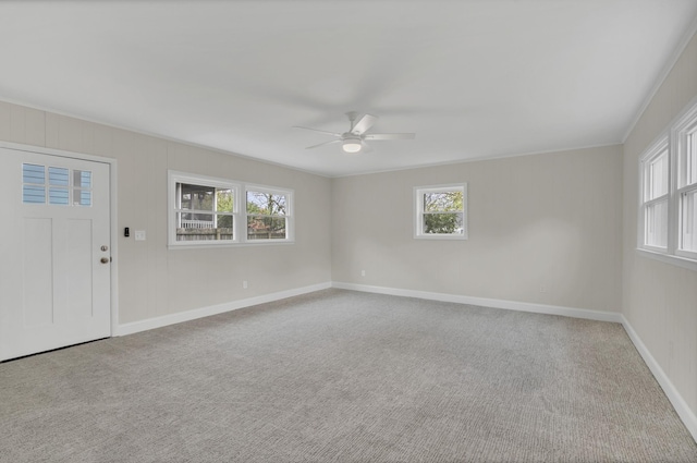 carpeted spare room with plenty of natural light and ceiling fan