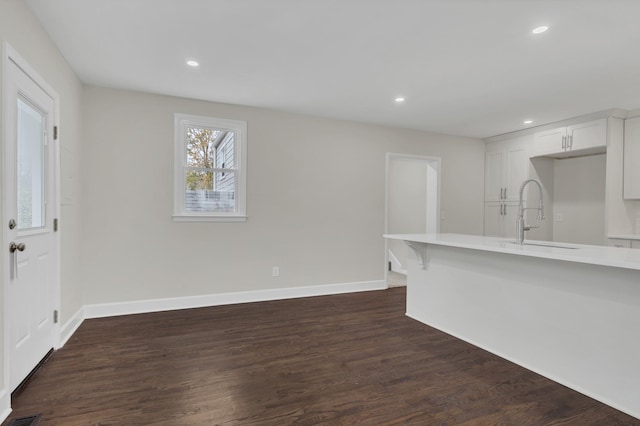 unfurnished living room with dark wood-type flooring and sink