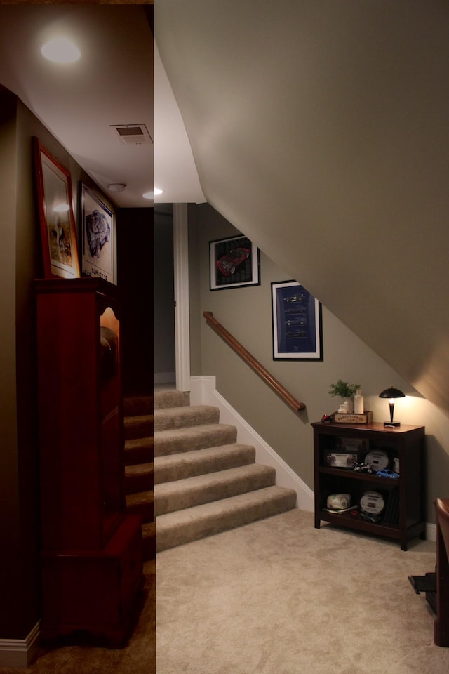 staircase with lofted ceiling and carpet flooring